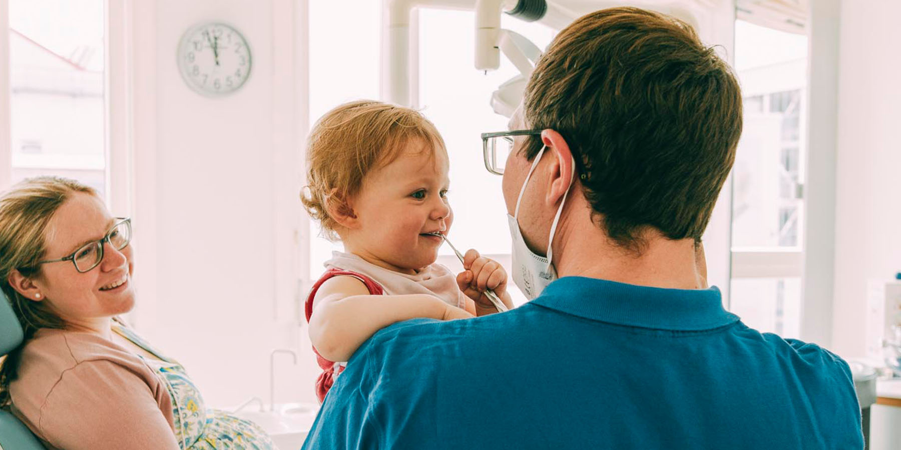 Zahnarzt Bernhard Scheiff zeigt einem Kind das richtige Zähneputzen
