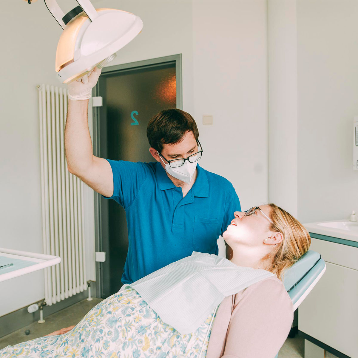 Zahnarzt Bernhard Scheiff richtet die Beleuchtung auf den Mund der Patientin